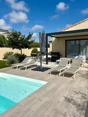 a patio with lounge chairs and a swimming pool at La villa du soleil in Lapalme