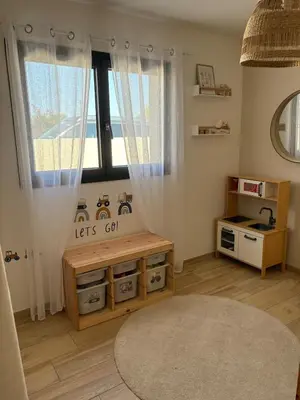 a childs room with a table and a window at La villa du soleil in Lapalme