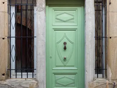 a green door on the side of a building at D'une maison à l'autre in Cépie