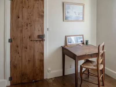 a room with a wooden table and a wooden door at D'une maison à l'autre in Cépie