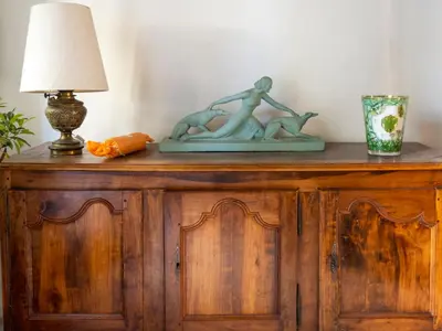 a wooden cabinet with a lamp on top of it at D'une maison à l'autre in Cépie