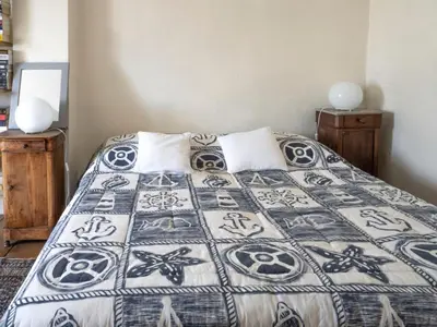 a bedroom with a bed with a bedspread with skulls at D'une maison à l'autre in Cépie