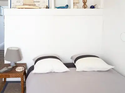 a white bed with two pillows on top of it at D'une maison à l'autre in Cépie