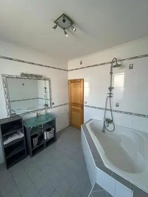 a bathroom with a tub and a sink and a mirror at L'Escapade Narbonnaise in Narbonne