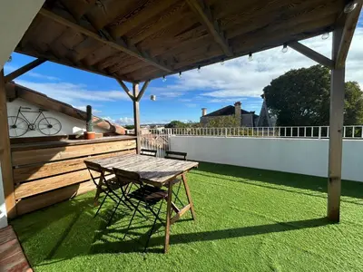 a wooden table and chair on a patio with grass at L'Escapade Narbonnaise in Narbonne
