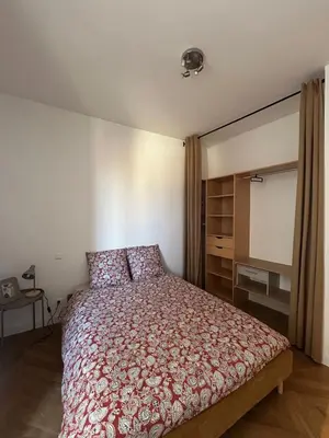 a bedroom with a bed with a red bedspread at L'Escapade Narbonnaise in Narbonne