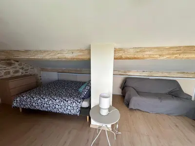 a bedroom with a bed and a table in a room at L'Escapade Narbonnaise in Narbonne