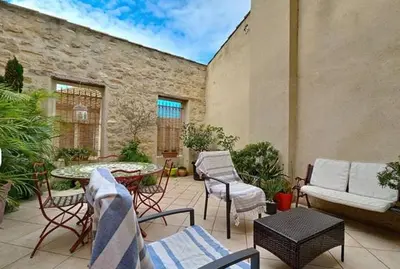an outdoor patio with chairs and a table and a table at La Maison Bleue de Sigean - Loft 1 in Sigean