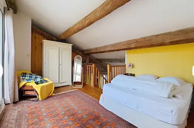a bedroom with a white bed and a yellow wall at La Maison Bleue de Sigean - Loft 1 in Sigean