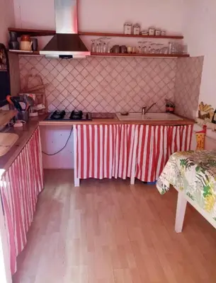 a kitchen with red and white striped counters and a table at La Maison Bleue de Sigean - Loft 1 in Sigean