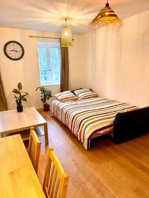 a bedroom with a bed and a table and a clock at Saint-Germain T2 Residence Apartment in Carcassonne