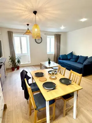 a living room with a table and a blue couch at Saint-Germain T2 Residence Apartment in Carcassonne