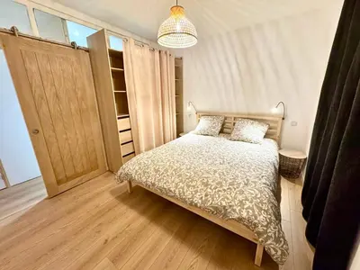 a bedroom with a bed and a closet and a chandelier at Saint-Germain T2 Residence Apartment in Carcassonne