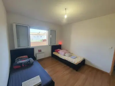 a bedroom with two beds and a window at Maison confortable à Carcassonne avec jardin privé in Carcassonne