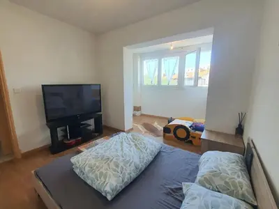 a living room with a bed and a flat screen tv at Maison confortable à Carcassonne avec jardin privé in Carcassonne