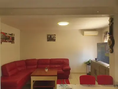 a living room with a red couch and a table at Maison confortable à Carcassonne avec jardin privé in Carcassonne