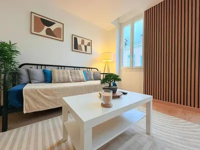 a living room with a bed and a table at L'Atelier Bohème - Studio élégant en centre ville in Pamiers
