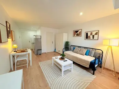 a living room with a couch and a table at L'Atelier Bohème - Studio élégant en centre ville in Pamiers