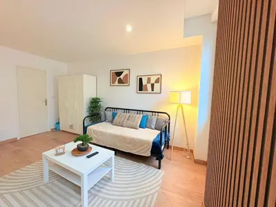 a bedroom with a bed and a table in a room at L'Atelier Bohème - Studio élégant en centre ville in Pamiers