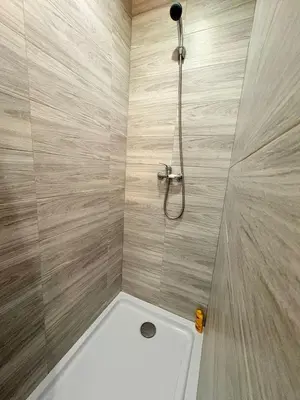 a bathroom with a shower with a white tub at L'Écrin Signature, Studio élégant en centre-ville in Pamiers