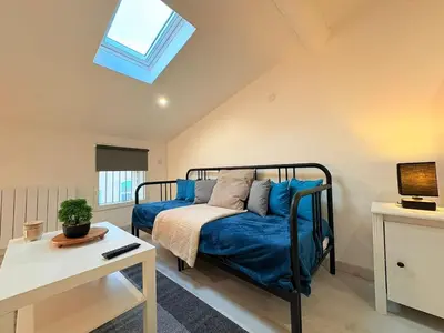 a bedroom with a bed with blue sheets and a skylight at L'Écrin Signature, Studio élégant en centre-ville in Pamiers
