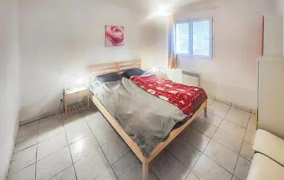a small bedroom with a bed and a table at Pause Nature Avec Piscine in Ferrières-Poussarou