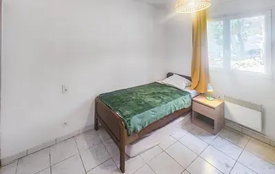 a small bedroom with a bed and a window at Pause Nature Avec Piscine in Ferrières-Poussarou