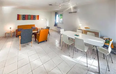 a living room with a white table and chairs at Pause Nature Avec Piscine in Ferrières-Poussarou