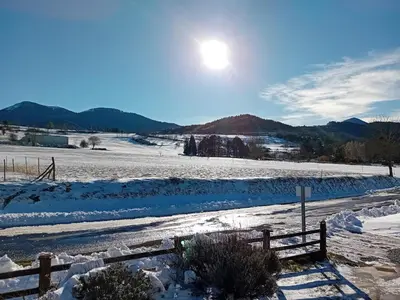 a snow covered field with the sun in the sky at Chalet du Plateau de Sault 6 personnes in Espezel