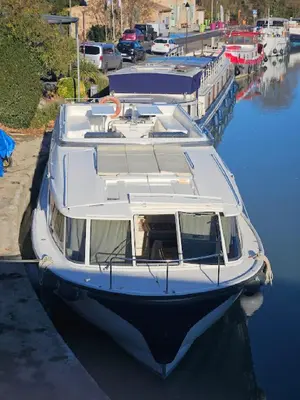 a white boat is docked in a harbor at BATEAU NAVYLIS Croisière in Capestang