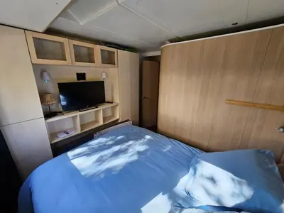 a bedroom with a bed and a flat screen tv at BATEAU NAVYLIS Croisière in Capestang