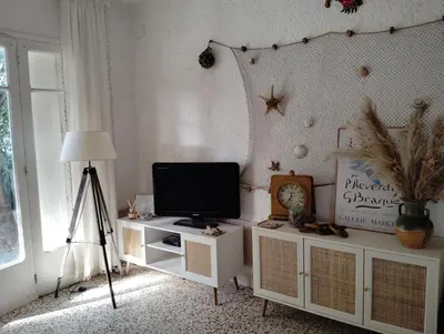 a room with a television on a stand with a tripod at Appartement bord de mer in Port-la-Nouvelle