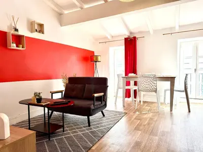 a living room with a chair and a table at L'Etoile Rouge - T2 Proche Gare et Centre Ville in Carcassonne