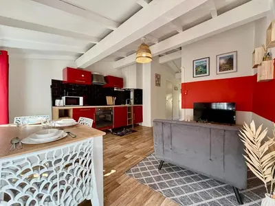 a kitchen with red and white walls and a table at L'Etoile Rouge - T2 Proche Gare et Centre Ville in Carcassonne