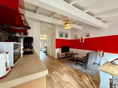 a kitchen and living room with red accent walls at L'Etoile Rouge - T2 Proche Gare et Centre Ville in Carcassonne