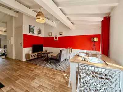 a living room with a red accent wall at L'Etoile Rouge - T2 Proche Gare et Centre Ville in Carcassonne