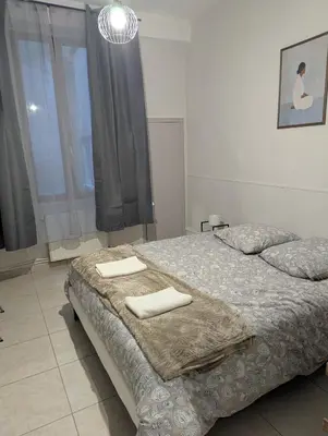 a bedroom with two beds and a large window at Cosy Bastide 4 personnes in Carcassonne