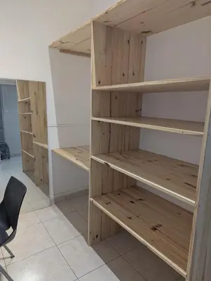 a room with wooden shelves and a chair at Cosy Bastide 4 personnes in Carcassonne