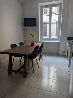 a dining room with a wooden table and chairs at Cosy Bastide 4 personnes in Carcassonne