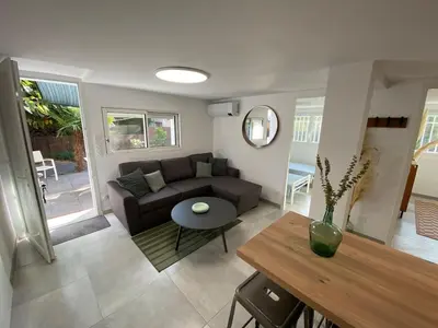 a living room with a couch and a table at Appartement 2 chambres proche centre ville avec jardin in Narbonne