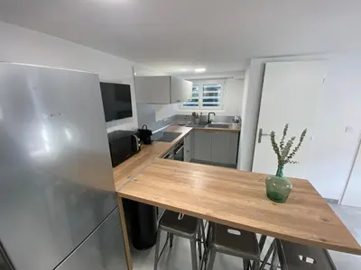 a kitchen with a wooden table with a vase on it at Appartement 2 chambres proche centre ville avec jardin in Narbonne