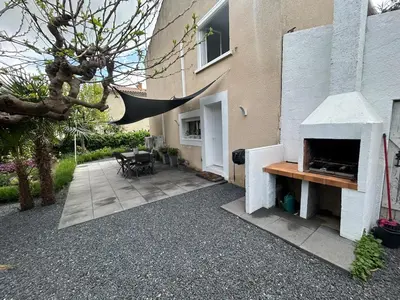 a patio with a pizza oven next to a building at Appartement 2 chambres proche centre ville avec jardin in Narbonne