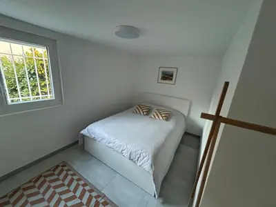 a small bedroom with a bed and a window at Appartement 2 chambres proche centre ville avec jardin in Narbonne