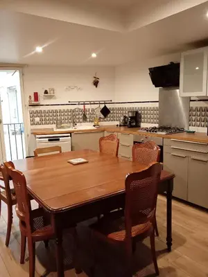 a kitchen with a wooden table and chairs at Grande maison 7 places in Paziols