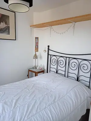 a bedroom with a white bed with a black headboard at Grande maison 7 places in Paziols