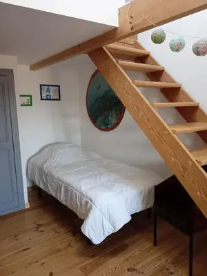 a bedroom with a bunk bed and a ladder at Grande maison 7 places in Paziols