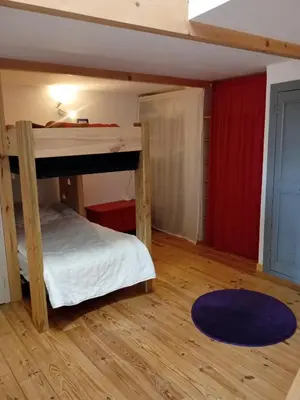 a bedroom with a bunk bed and a blue rug at Grande maison 7 places in Paziols