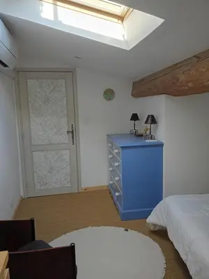 a bedroom with a bed and a blue dresser and a door at Grande maison 7 places in Paziols