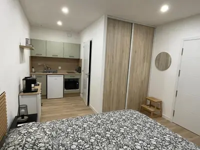 a small bedroom with a bed and a kitchen at Studio rénové pour 2 personnes - centre ville in Carcassonne