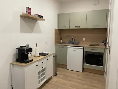 a small kitchen with white cabinets and a sink at Studio rénové pour 2 personnes - centre ville in Carcassonne